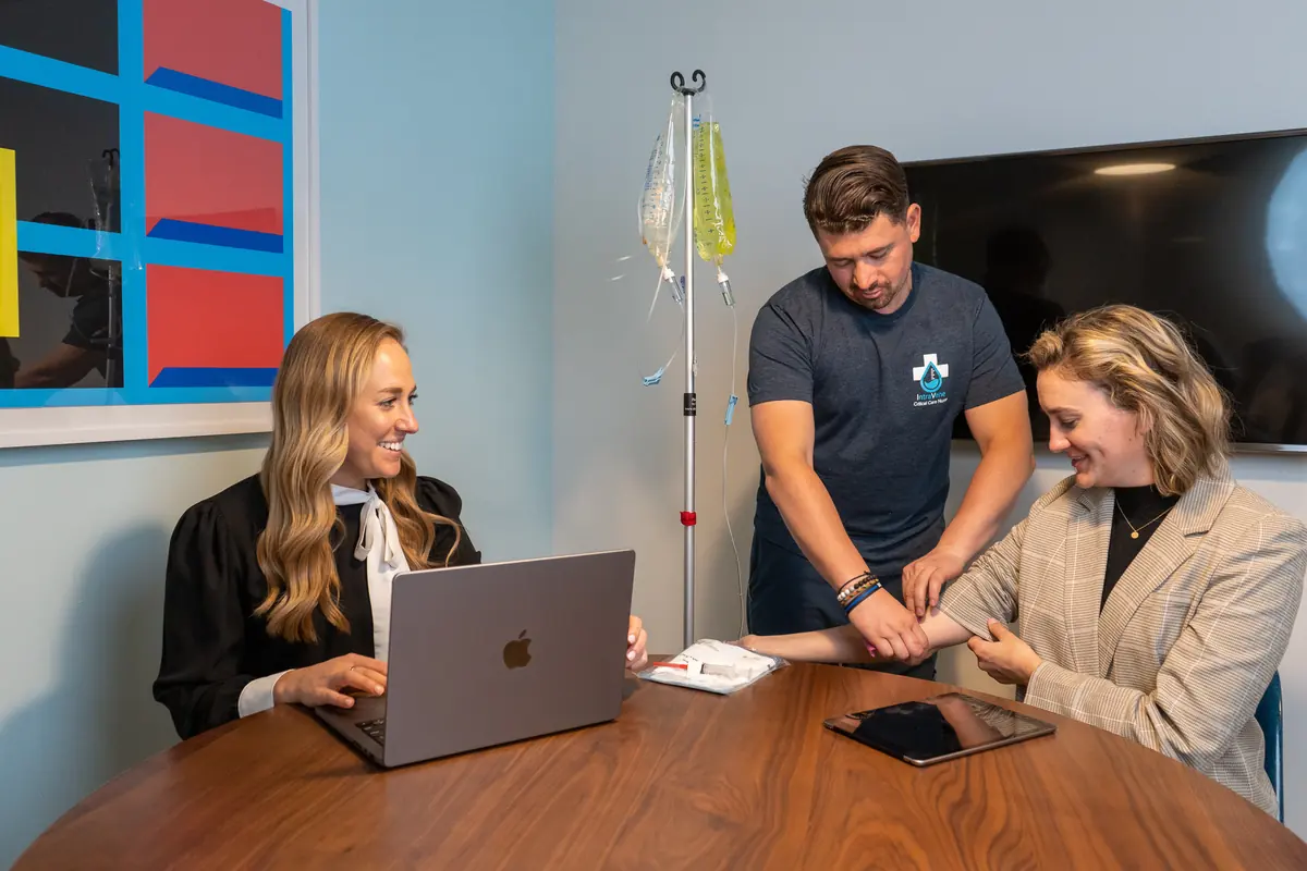 An Intravene registered nurse starting an IV drip for a client during a home visit