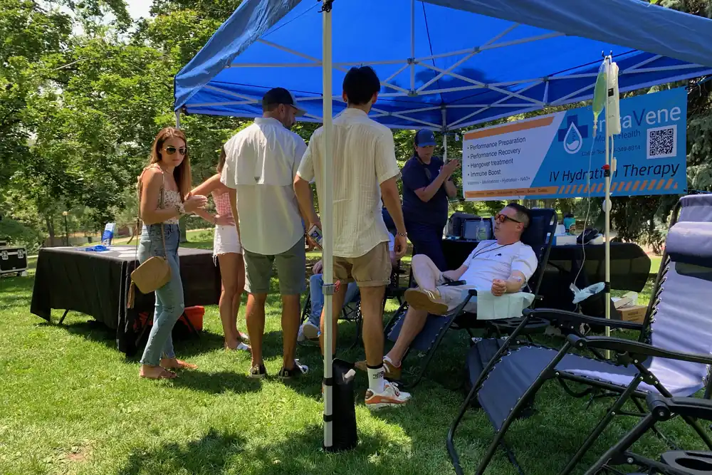 Nurses running a mobile IV hydration station under a tent at a Front Range park event